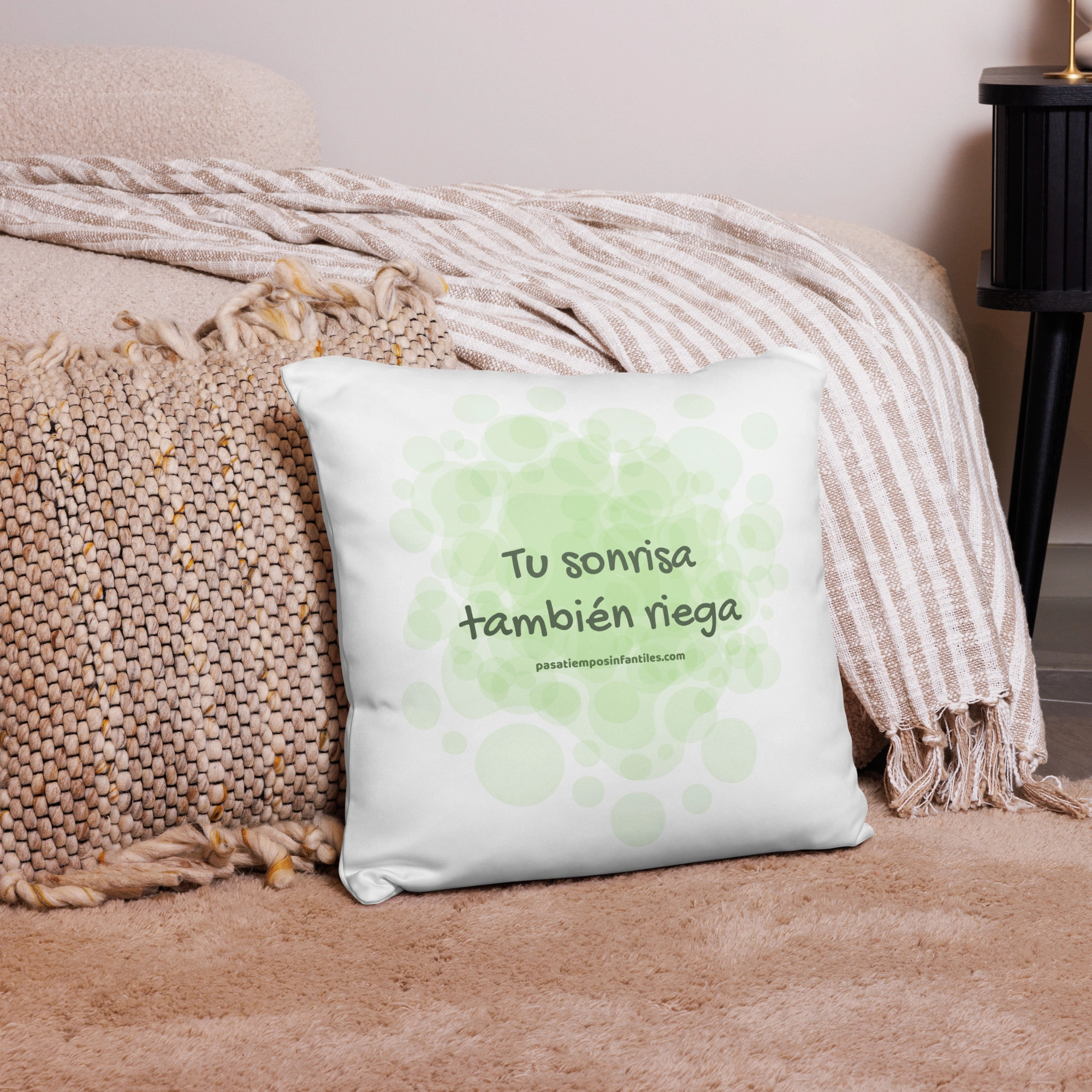 Cojín con frase positiva sobre alfombra y manta decorativa trasera